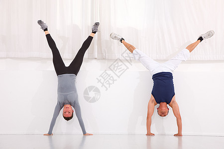 在健身房里做手立运动的男男女女朋友们建造福利瑜伽锻炼窗帘平衡力量姿势身体图片