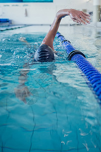 在游泳池打前中风的健身游泳运动员游泳镜身体游泳衣行程水池活动中心休闲运动服运动图片