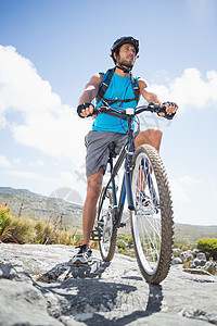 适合在岩石地形上骑自行车的人越野头盔闲暇阳光风景蓝天冒险踪迹荒野男性图片