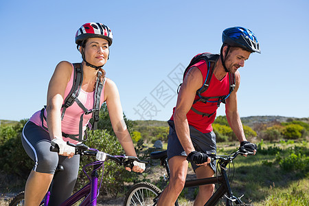 越野自行车农村在业夫妇骑自行车的情况活动勘探踪迹闲暇夫妻冒险家晴天山地越野骑术背景