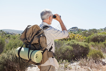 在国家足迹上通过望远镜寻找希克人冒险远足勘探男性环境阳光闲暇背包小路假期图片