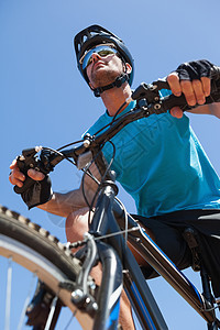 在国道上骑脚踏车的赛车运动员骑术荒野男性风景活动晴天头盔蓝天越野踪迹图片