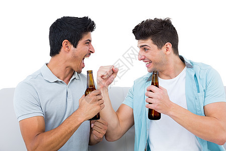 足球迷欢乐与啤酒一起欢呼朋友快乐沙发活力扇子瓶子休闲男性酒精男人图片