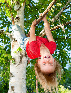 被吊在树枝上的儿童阳光微笑情感童年公园活动女孩快乐桦木孩子图片