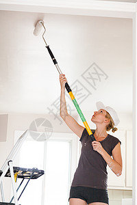 妇女画天花板  的特写装潢师房子刷子女士工作维修装潢女性家务房间图片