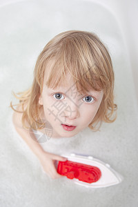 在浴缸里的男孩气泡浴室乐趣童年泡沫塑料玩具卫生金发头发图片