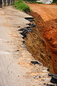 路旁的沥青路侧面自1995年12月1日以来倒塌和倒塌脆皮衰变地球损害危险黏土图层岩石杂草环境图片