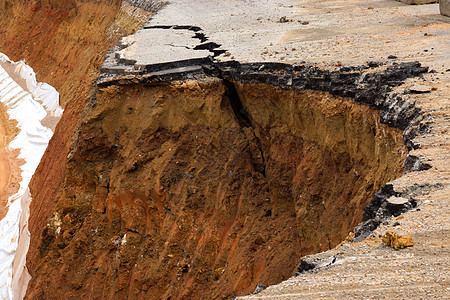 路旁的沥青路侧面自1995年12月1日以来倒塌和倒塌环境图层损害土壤地球脆皮材料杂草黏土岩石图片