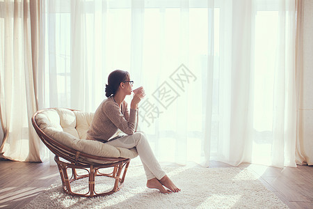 女人在椅子上放松窗户公寓咖啡女孩情绪扶手椅生活客厅沙发家具图片