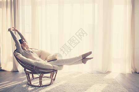 女人在椅子上放松房间地毯酒店白色公寓窗户扶手椅女孩女性温暖图片