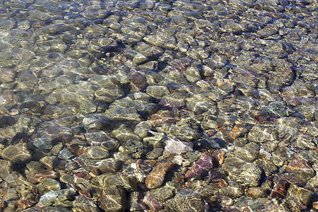 水中的岩石溪流涟漪蓝色卵石石头水晶阳光树叶图片