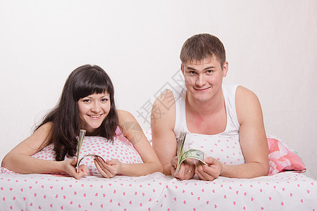 女孩和男人 在床上 一瓦美元的美元图片
