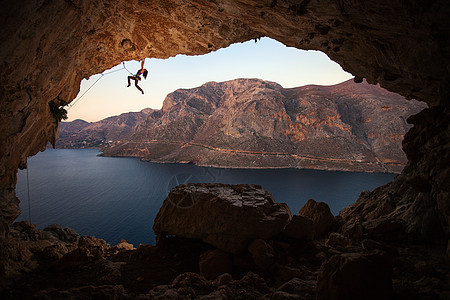 山洞悬崖上女性攀岩者的休眠图片
