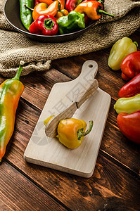 用木刀切胡椒红色绿色辣椒营养白色食物生物黄色烹饪蔬菜图片