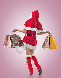 持有购物袋的圣诞女孩购物者庆祝裙子女士假期销售零售消费者活动购物中心图片