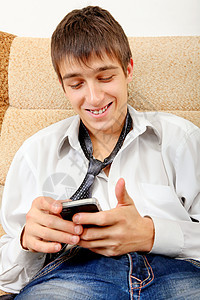 带手机的青少年互联网男性男人领带长椅小伙子房间衬衫短信工具图片