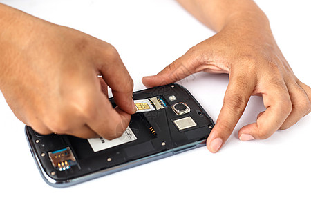 手持SIM卡并安装在白色隔离的智能手机上活力电缆力量电话电池技术收费屏幕生活模拟图片