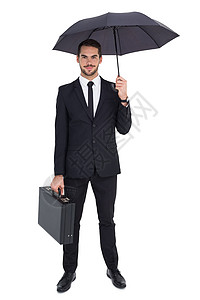 持有公文包时在伞下微笑的商务人士图片