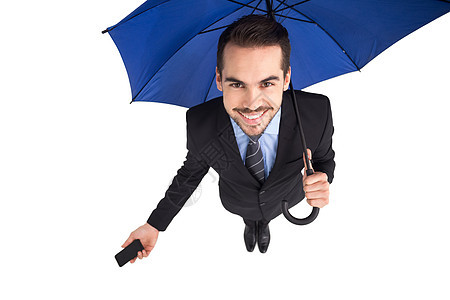 手持智能手机的伞下微笑的商务人士图片