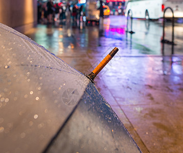 在时代广场的雨夜上打开雨伞图片