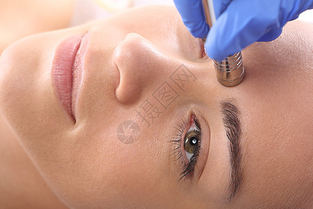 在美容院进行微红外膜治疗时 放松的妇女前额皮肤科医学医师零售手术女性注射粉刺化妆品图片