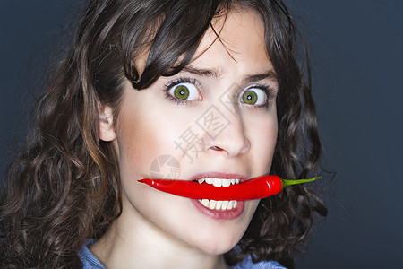 女人嘴里握着辣椒食物女孩情感香料女性红色胡椒蔬菜女士嘴唇图片