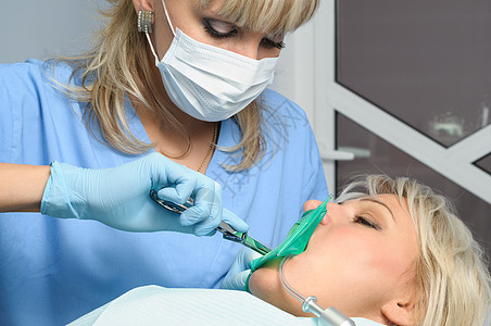 配备有病人的牙医 安装橡胶大坝女性橡胶坝医生钳子手术口服乐器围堰萃取治疗图片