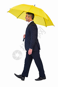 商务人士步行和持有黄色伞式的黄伞图片
