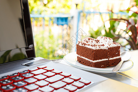巧克力蛋糕和笔记本电脑早餐技术饮食互联网键盘背景甜点盘子食物蛋糕图片