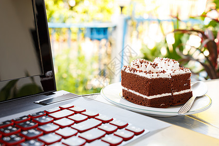 巧克力蛋糕和笔记本电脑休息技术蛋糕饮食背景房子互联网植物早餐奶油图片