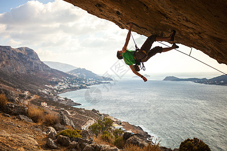 男性登山者攀爬在悬浮的岩石上太阳绳索男人挑战高度悬崖风景日落运动成人图片