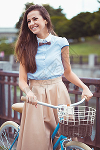 年轻美丽 穿着优雅打扮的女人 骑着自行车在平原上花朵日落女孩裙子潮人身体旅行蝴蝶女士生活图片