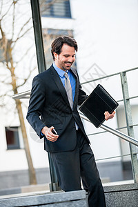 微笑的商务人士下楼梯走下去文件夹电话经理蓝衬衫套装中介男人领带活力男性图片