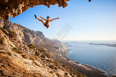 女性攀岩者倒在悬崖上绳索岩石失败登山者日落高度洞穴挑战女孩天空图片