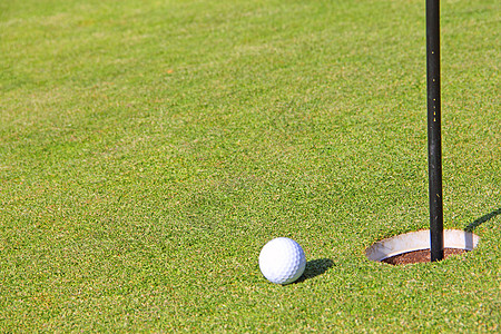 高尔夫球在杯嘴边齿轮白色绿色游戏娱乐运动课程旗帜俱乐部竞赛图片