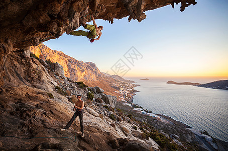 男性攀岩者爬上山洞中的屋顶成功悬崖岩石天空运动高度绳索洞穴成人登山者图片