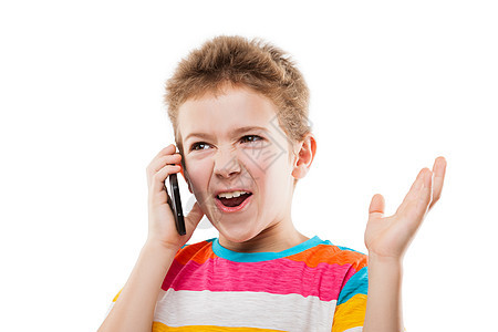 儿童男孩在讲手机或智能电话时感到惊讶和震惊图片
