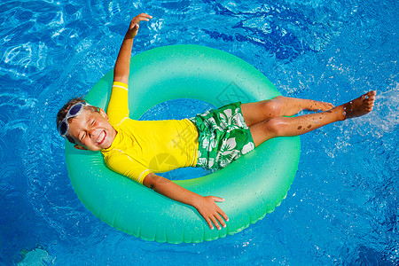 男孩在游泳池游泳腰带童年幸福男性运动享受乐趣闲暇公园水池图片