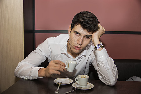 在桌边喝杯咖啡的有压力男士图片