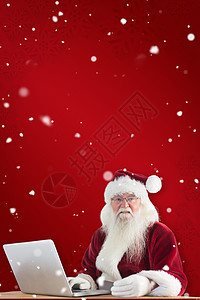 圣塔的复合图像 用笔记本电脑用信用卡支付胡须技术快乐桌子购物喜庆假期微笑男性雪花图片