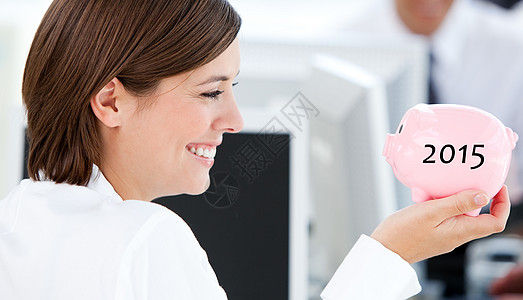 拥有小猪银行的笑容女商务人士的综合形象图片