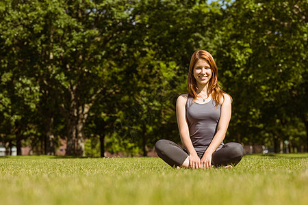 一个漂亮的红发美女坐着的肖像公园微笑身体调子快乐女士女性农村绿地瑜伽图片
