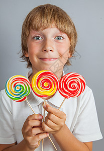 男孩吃棒棒棒糖金发食物婴儿乐趣微笑幼儿园小吃漩涡孩子喜悦图片