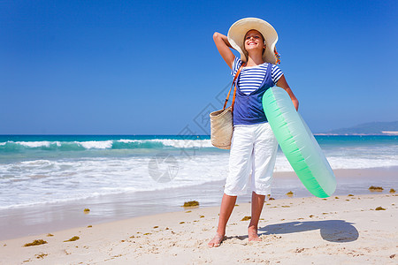 海滩上的女孩享受娱乐太阳旅行帽子季节旅游孩子晴天裙子图片