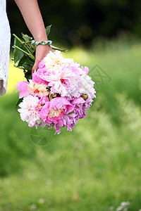 女人在户外手边的皮子花束季节植物群牡丹公园女士植物脆弱性生日假期婚礼图片
