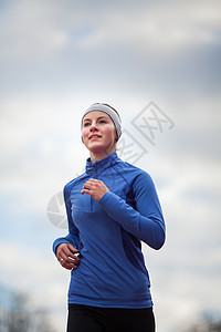 一个女人的肖像与蓝天对着跑运动女孩竞技活动竞赛女士运动装肌肉娱乐跑步图片