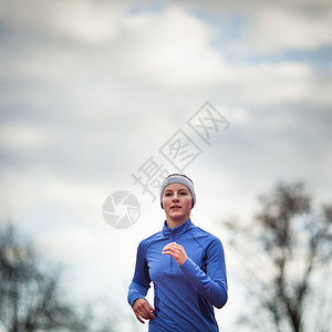 一个女人的肖像与蓝天对着跑快乐运动员竞赛闲暇竞技慢跑者娱乐训练微笑跑步图片