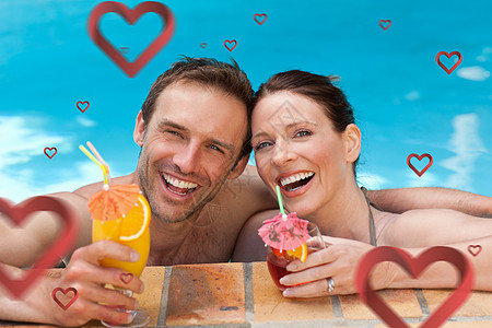 在游泳池喝鸡尾酒的一对漂亮的夫妇 综合图象享受假期太阳夫妻男性酒精女性情人比基尼男人图片