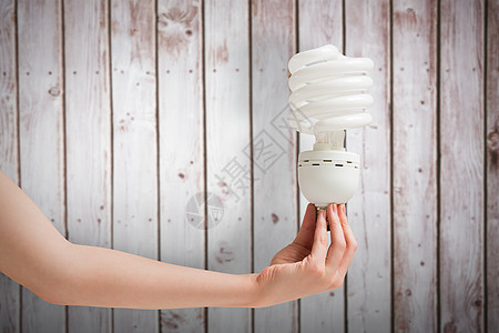 手持节能灯泡复合图像图象绿色木头绘图效率能源电气木板活力技术经济图片