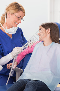 微笑的儿科牙医安慰她的年轻病人考试牙科医疗工作成人保健保健员职业手套女孩图片